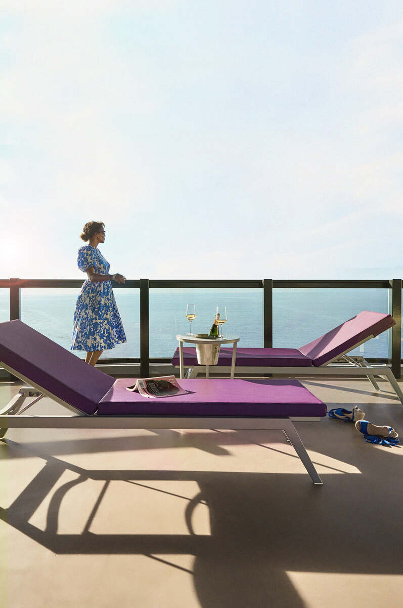 Guest enjoying a private balcony suite at sea aboard Virgin Voyages
