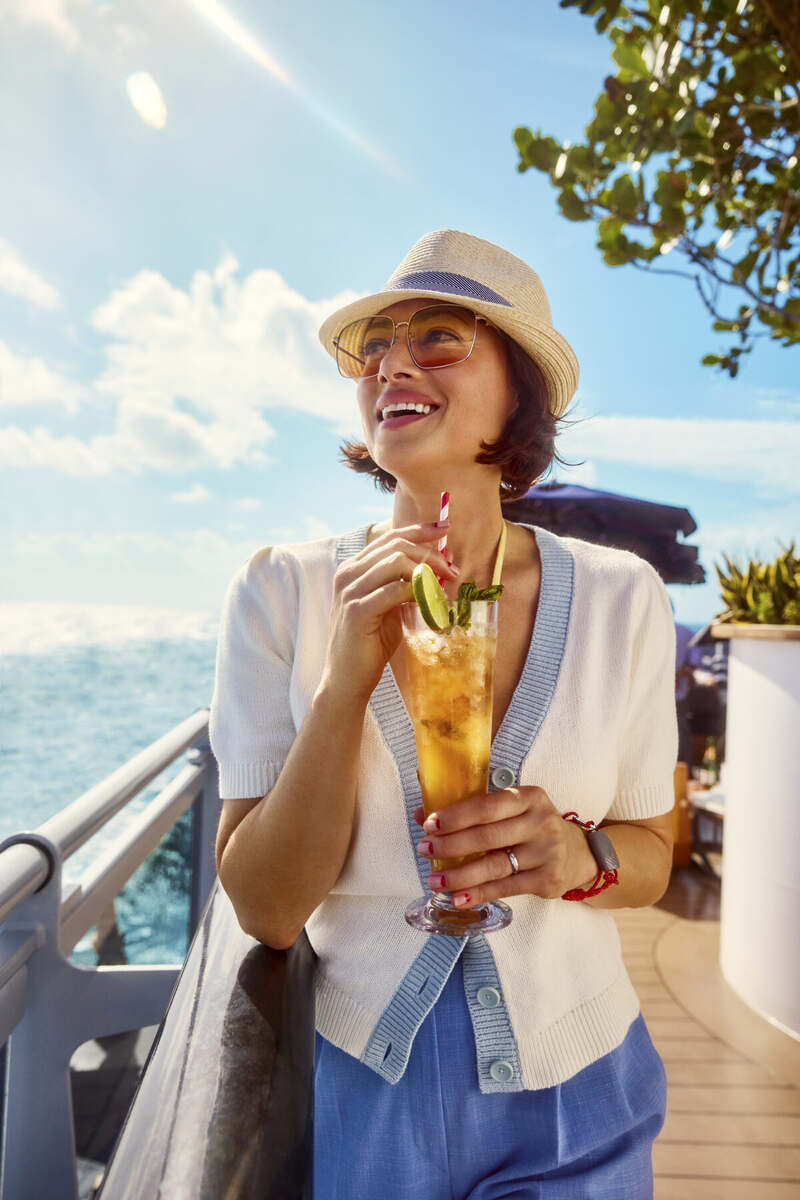 Guest enjoying a cocktail on deck at golden hour